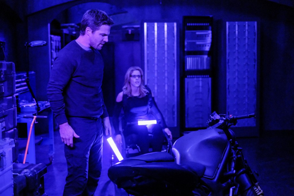Oliver et Fleicity regardent des preuves sur la moto à l'aide des leds fluorescentes