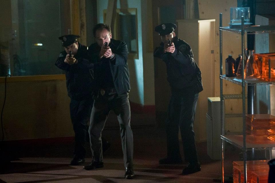 Quentin Lance (Paul Blackthorne) accompagné d'officiers de police
