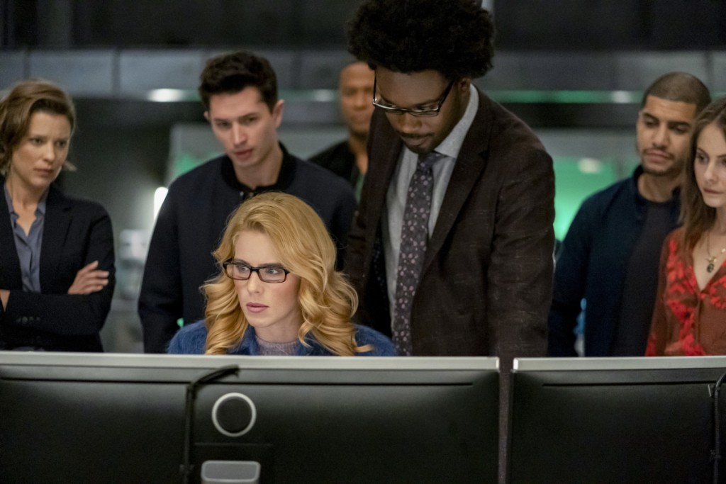 Felicity (Emily Bett Rickards) et Curtis Holt (Echo Kellum) travaillent sur les ordinateurs alors que le reste de l'équipe les regarde
